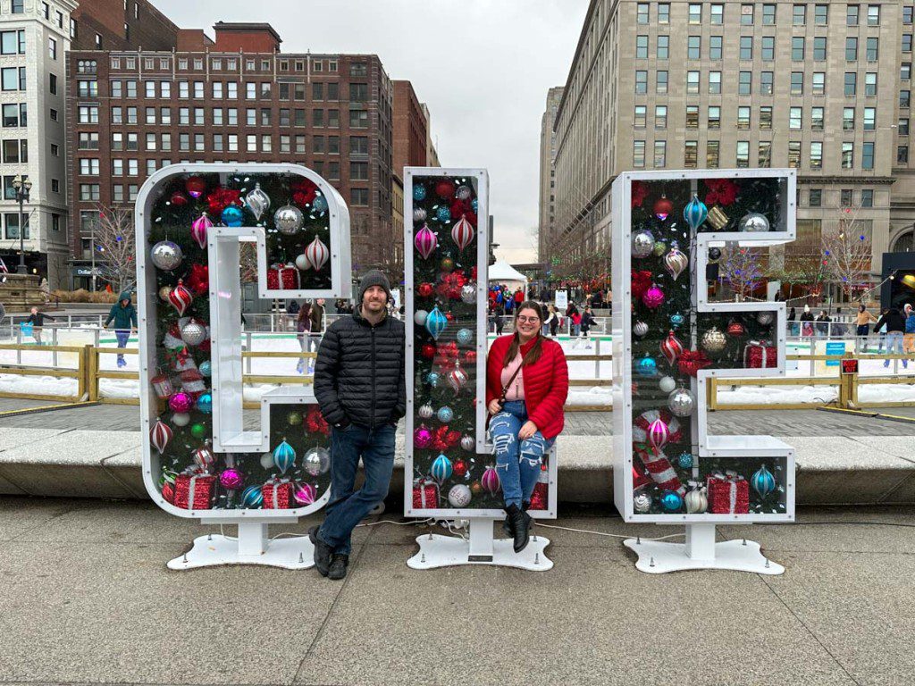 Amanda and Elliot with a holiday CLE sign in Public Square